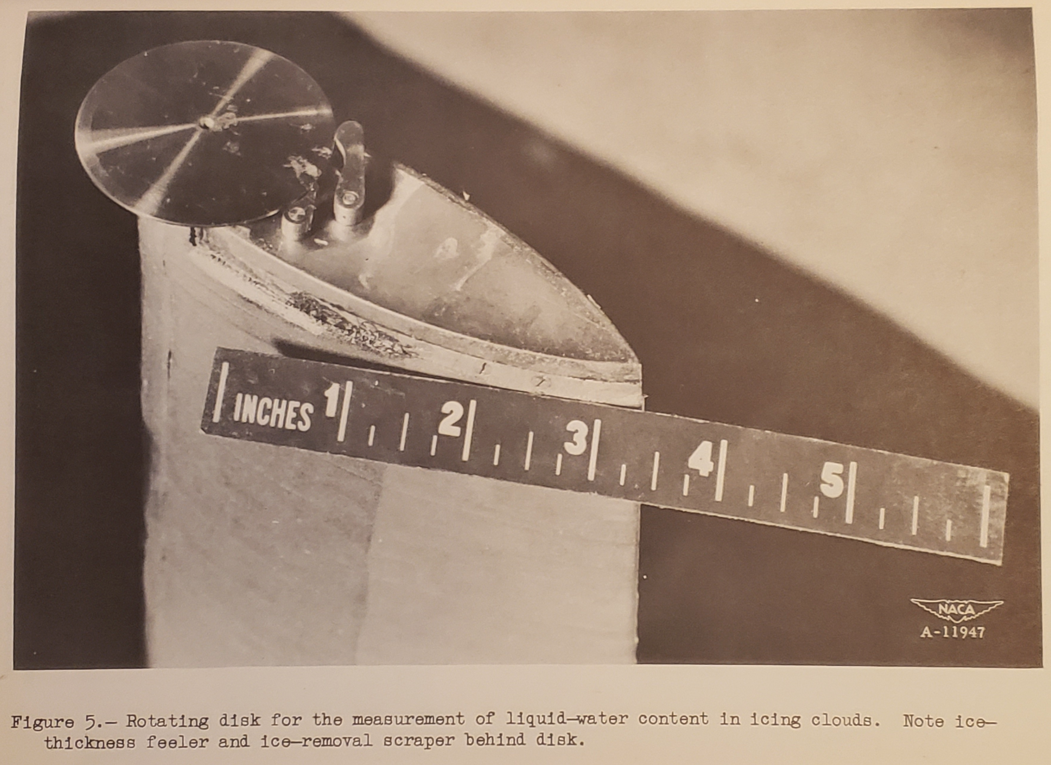 Figure 5. Rotating disk for the measurement of liquid-water content in icing clouds. Note ice-thickness feeler and ice removal scraper behind disk.